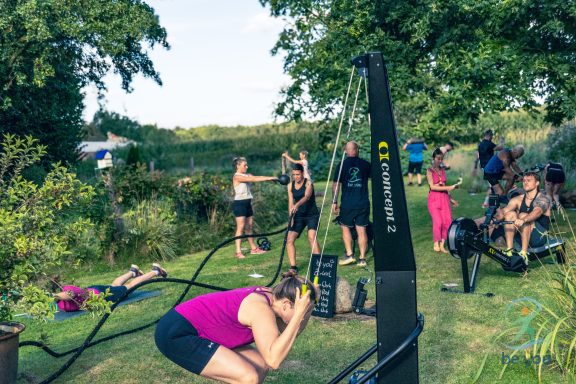 Gruppentraining im Freien mit verschiedenen Übungen und Fitnessgeräten.