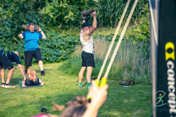 Gruppentraining im Freien mit verschiedenen Fitnessübungen und Übungen mit Gewichten.